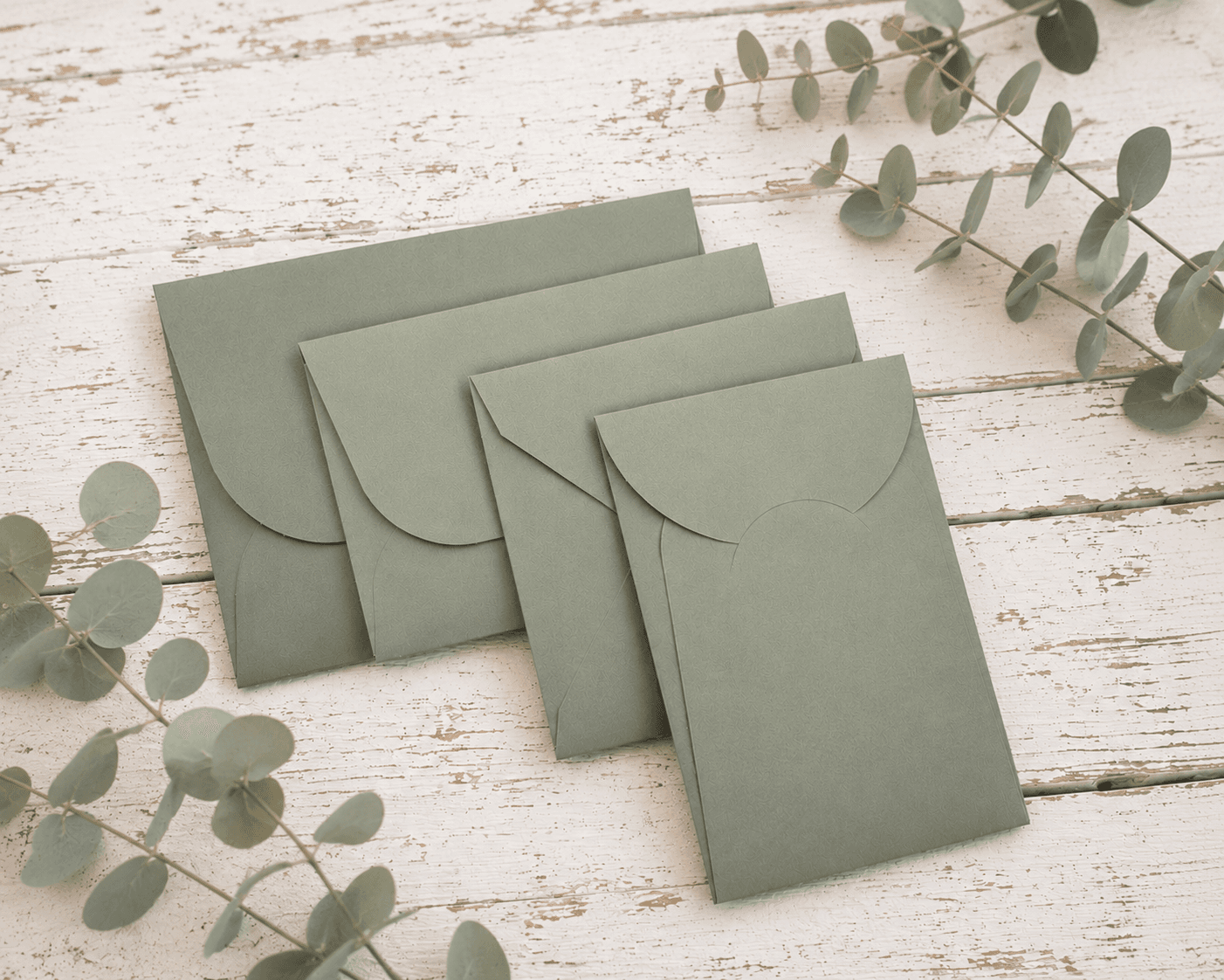 Buste artigianali verde salvia con rametti di eucalipto su tavolo in legno