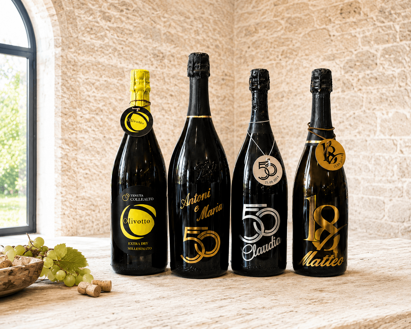 Quattro bottiglie di spumante personalizzate in fila su tavolo in cantina di pietra