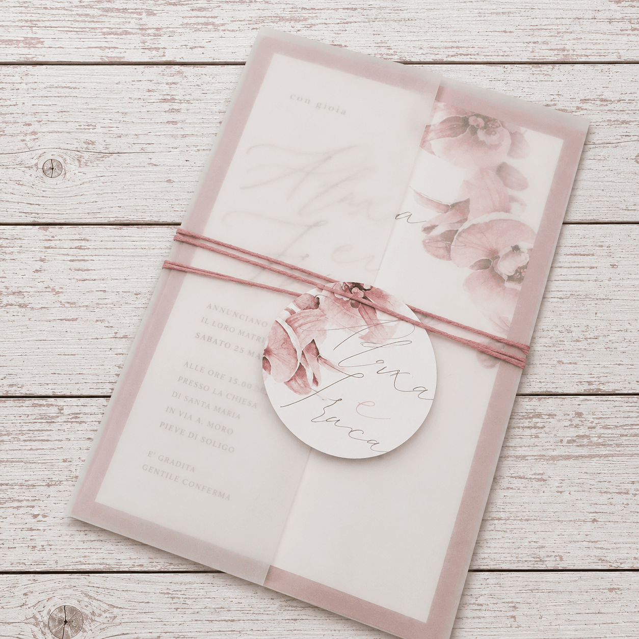 Partecipazione in carta velina rosa con fiori ad acquerello e etichetta rotonda